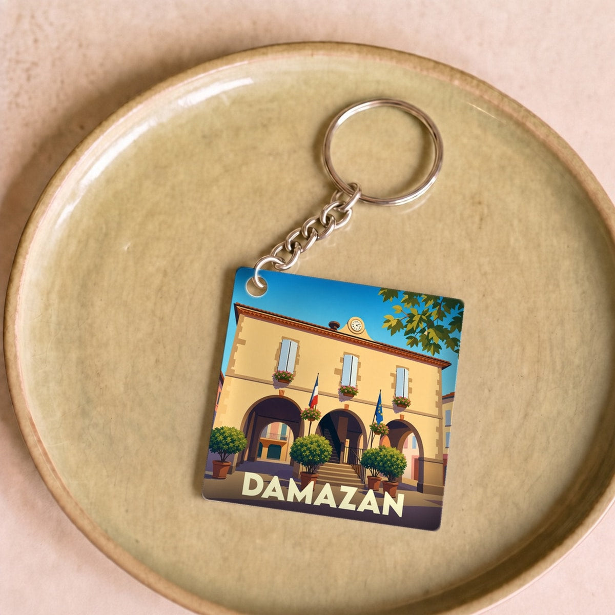 Porte-clés souvenir de la ville de Damazan avec une illustration stylisée de son hôtel de ville.