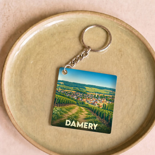 Porte-clés souvenir de la ville de Damery avec une illustration stylisée de ses vignobles.