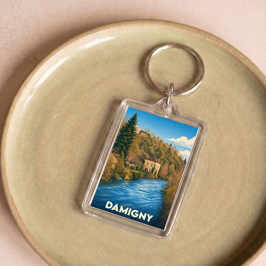 Porte-clés souvenir de la ville de Damigny avec une illustration stylisée d'un paysage fluvial.