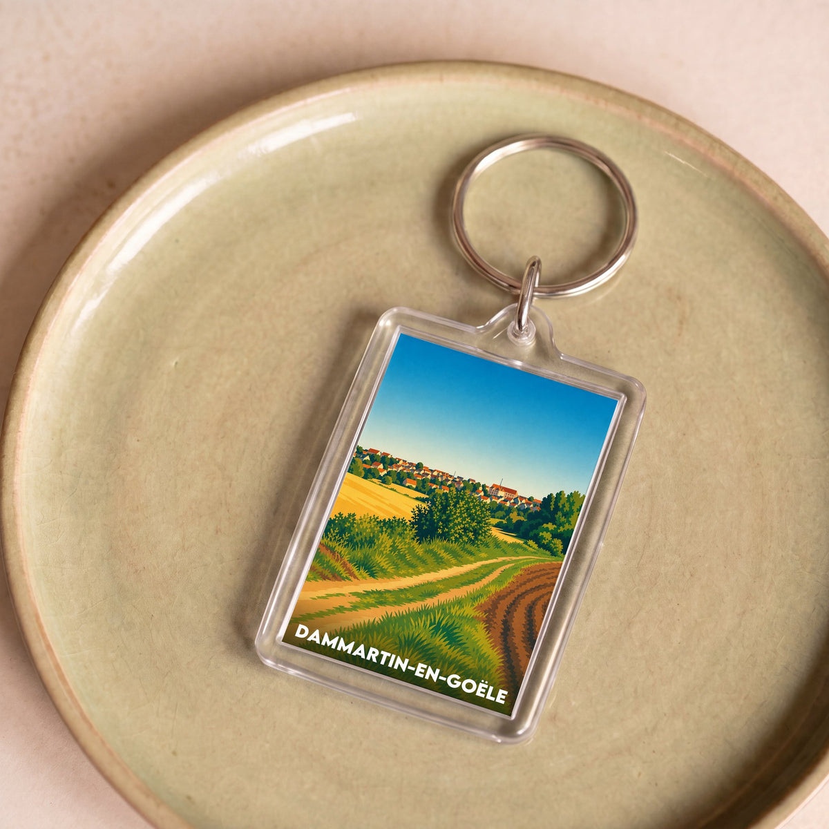Porte-clés souvenir de la ville de Dammartin-en-Goële avec une illustration stylisée.