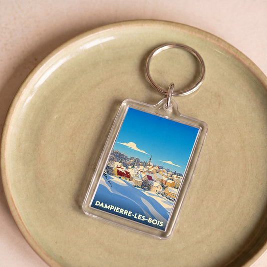 Porte-clés souvenir de la ville de Dampierre-les-Bois avec une illustration hivernale stylisée.