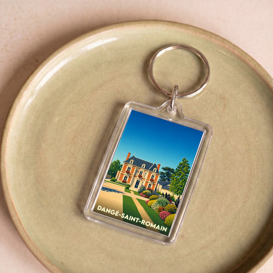 Porte-clés souvenir de la ville de Dangé-Saint-Romain avec une illustration stylisée d'un manoir fleuri.