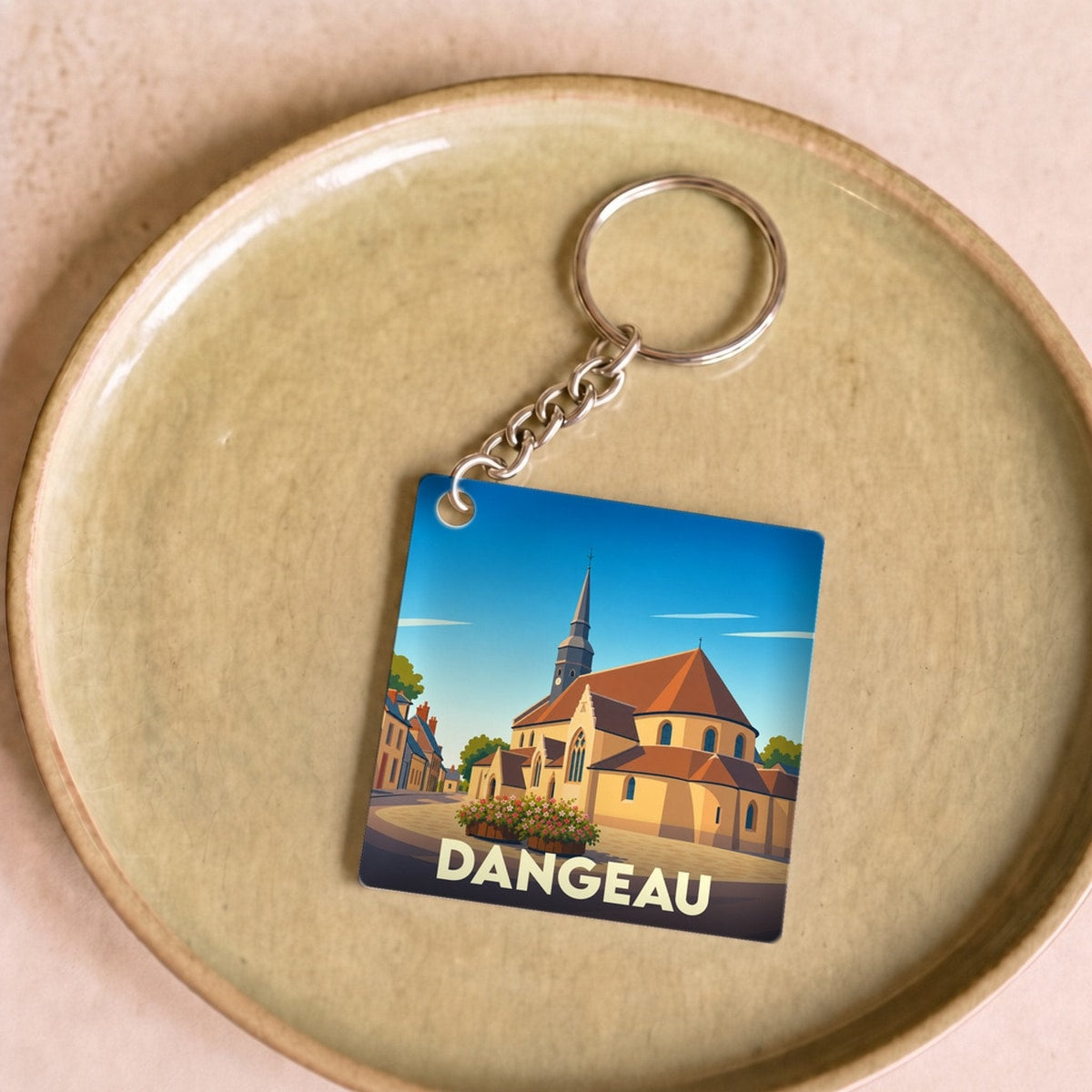 Porte-clés souvenir de la ville de Dangeau avec une illustration stylisée de son église.