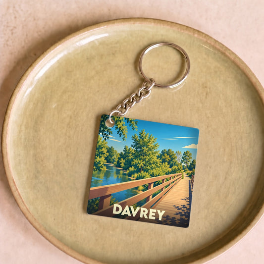 Porte-clés souvenir de la ville de Davrey avec une illustration stylisée d'un pont en bois sur une rivière.