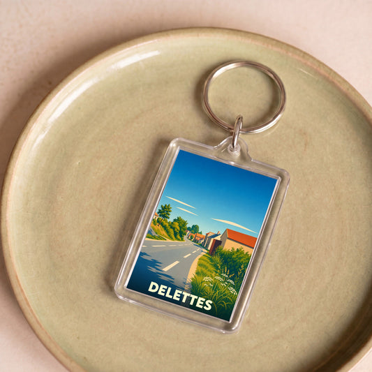 Porte-clés souvenir de la ville de Delettes avec une illustration stylisée d'un paysage de campagne.