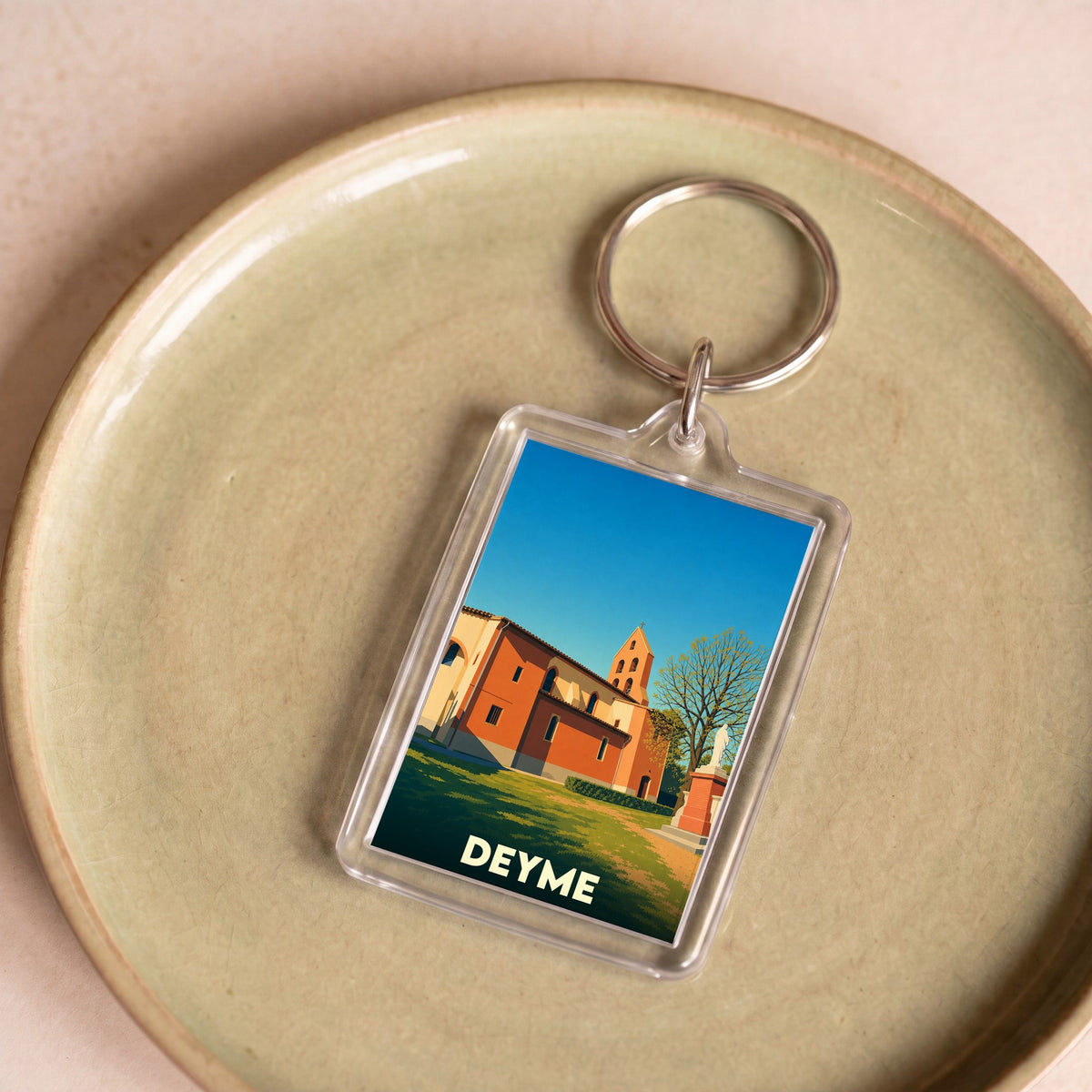 Porte-clés souvenir de la ville de Deyme avec une illustration stylisée de son église.