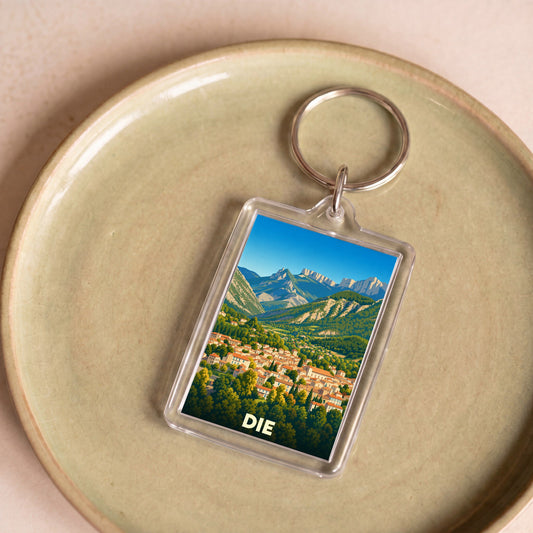 Porte-clés souvenir de la ville de Die avec une illustration stylisée d'un paysage montagneux.