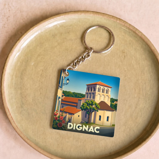 Porte-clés souvenir de la ville de Dignac avec une illustration stylisée d'une église romane.