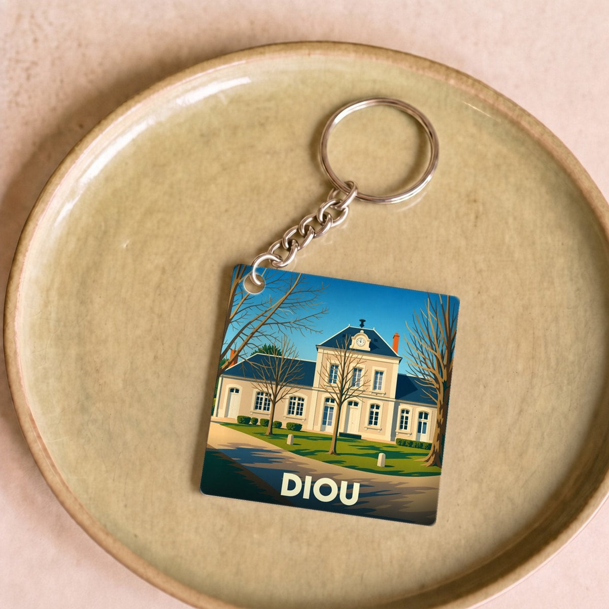 Porte-clés souvenir de la ville de Diou avec une illustration stylisée.