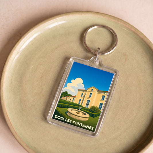 Porte-clés souvenir de la ville de Doix lès Fontaines avec une illustration stylisée d'un domaine et de sa fontaine.