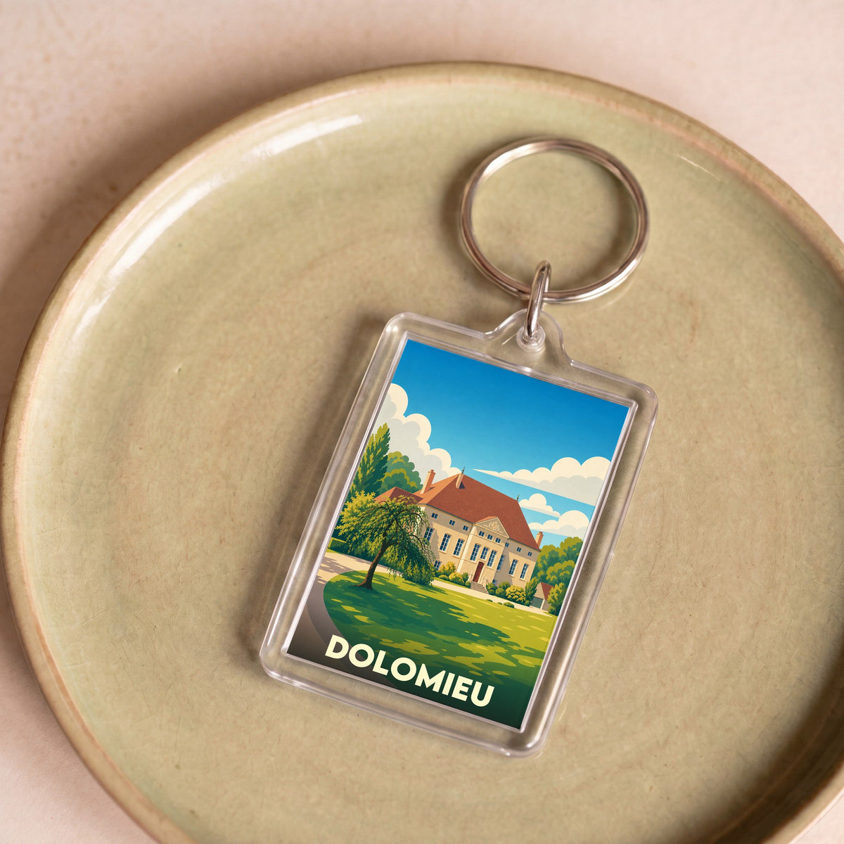 Porte-clés souvenir de la ville de Dolomieu avec une illustration stylisée d'une demeure bourgeoise.