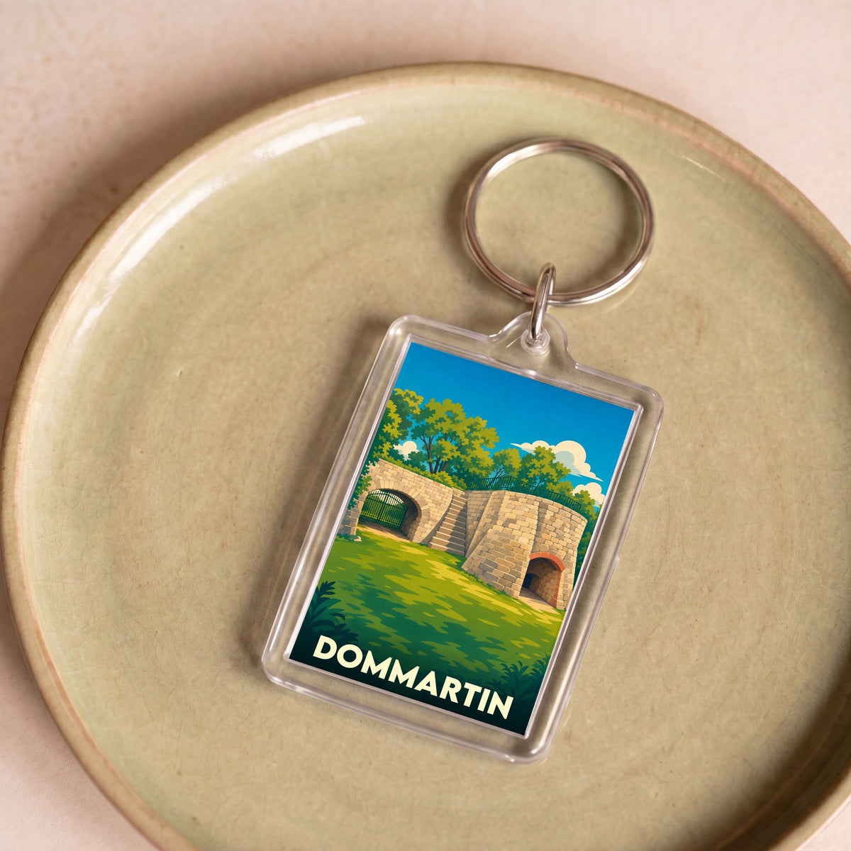Porte-clés souvenir de la ville de Dommartin avec une illustration stylisée.