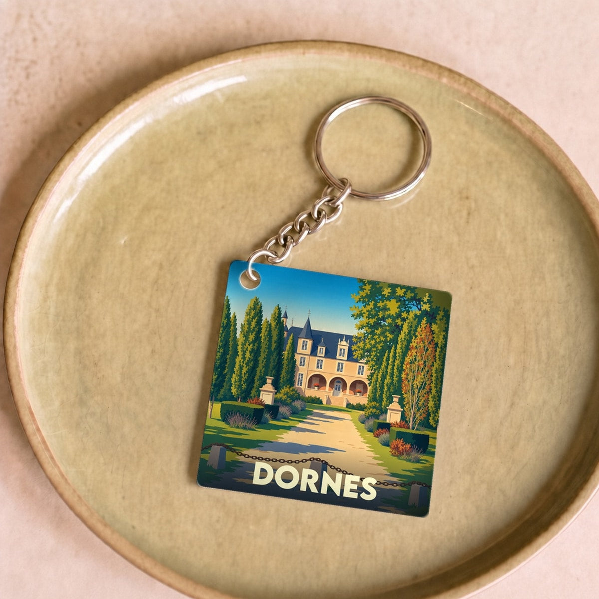 Porte-clés souvenir de la ville de Dornes avec une illustration stylisée d'un château.