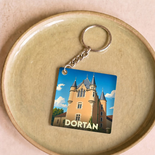 Porte-clés souvenir de la ville de Dortan avec une illustration stylisée de son château.