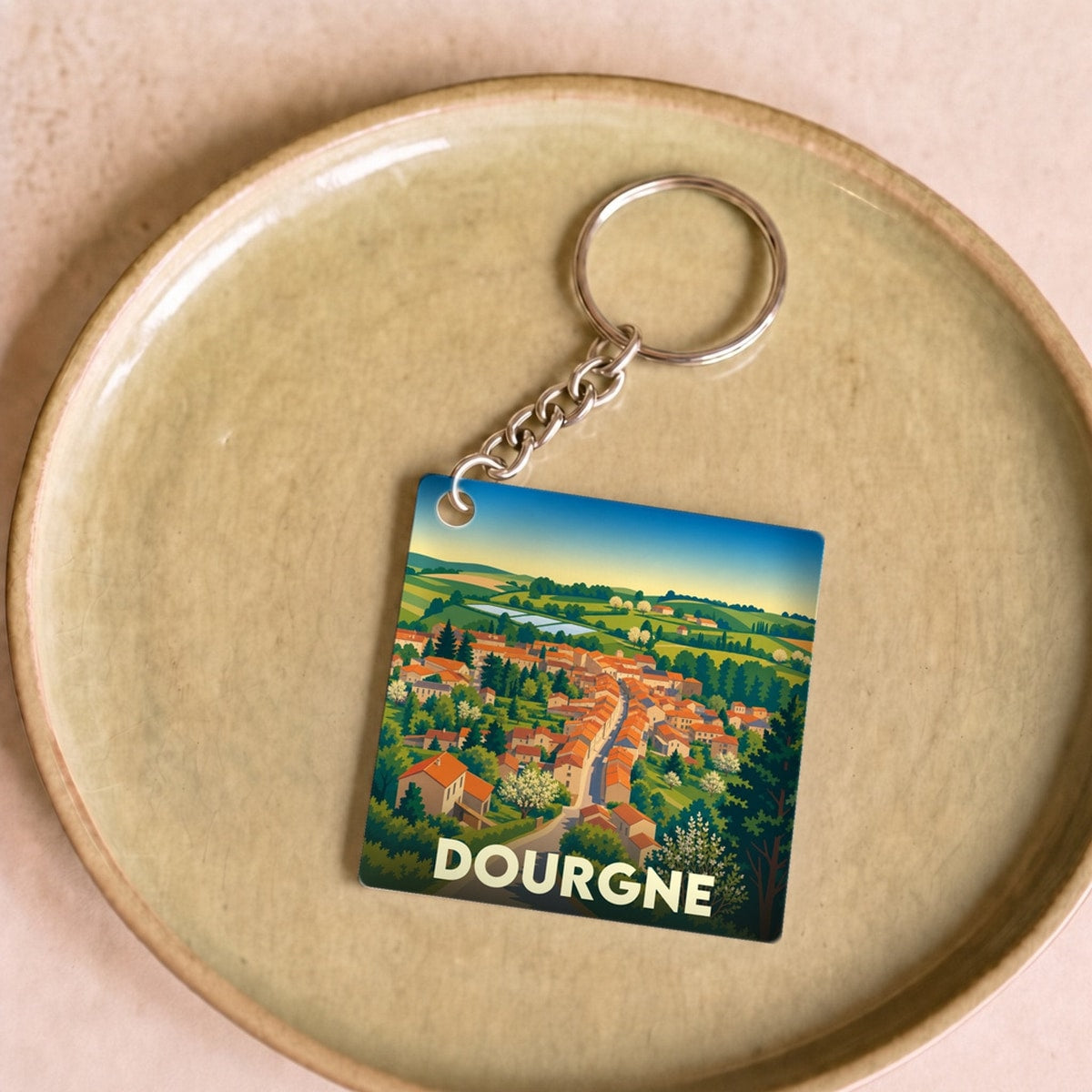 Porte-clés souvenir de la ville de Dourgne avec une illustration stylisée.