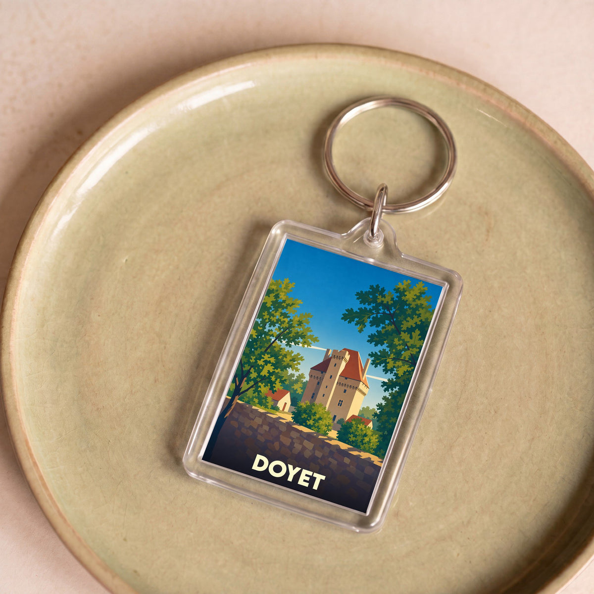 Porte-clés souvenir de la ville de Doyet avec une illustration stylisée d'un château.