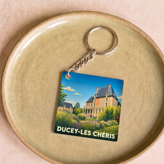 Porte-clés souvenir de la ville de Ducey-Les Chéris avec une illustration stylisée de son château.