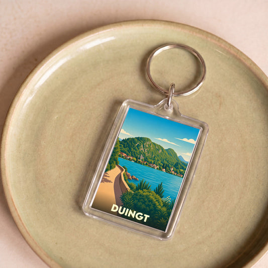 Porte-clés souvenir de la ville de Duingt avec une illustration stylisée du lac d'Annecy.