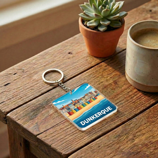Porte-clés souvenir de la ville de Dunkerque avec une illustration stylisée de sa plage et de ses cabines colorées.