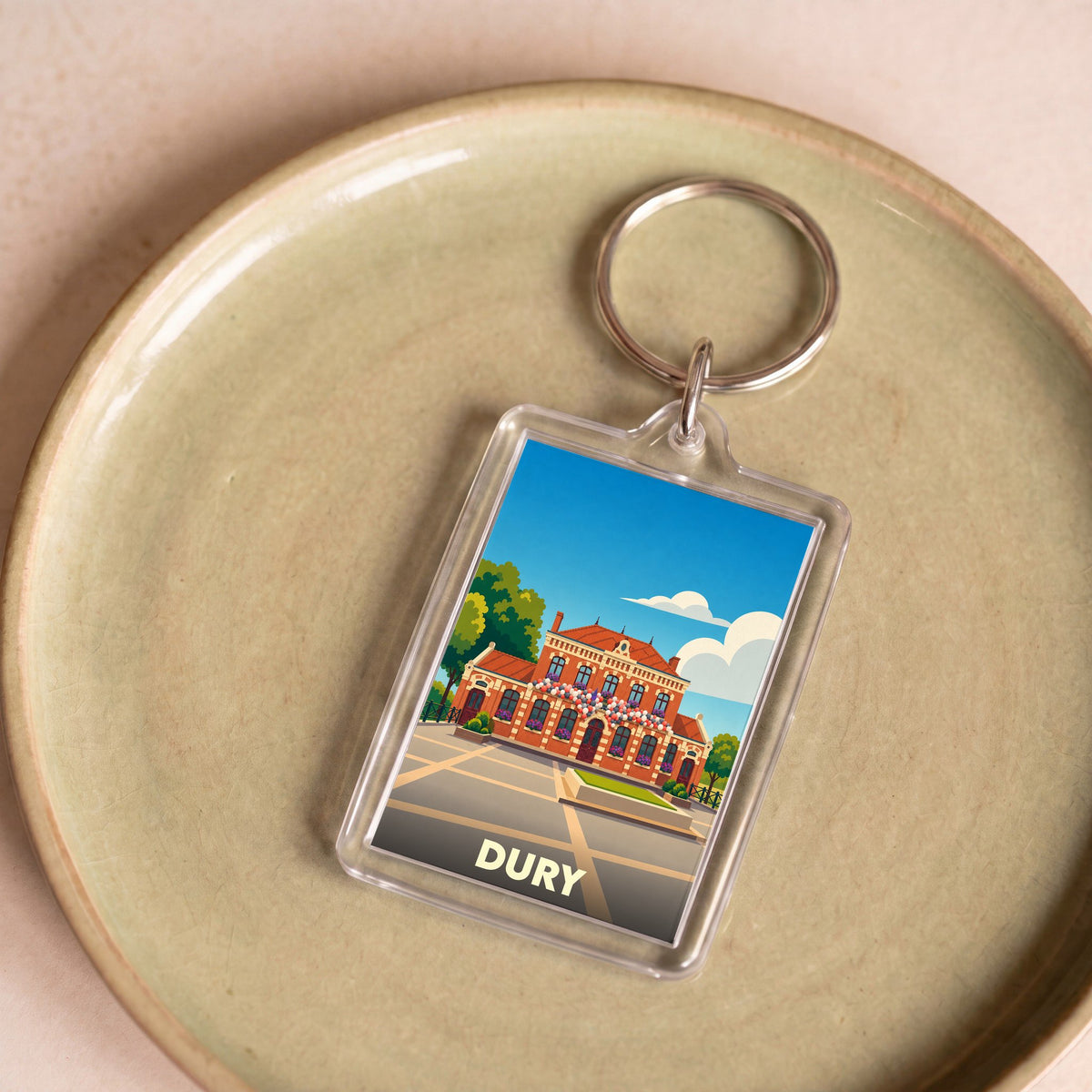 Porte-clés souvenir de la ville de Dury avec une illustration stylisée de sa mairie.