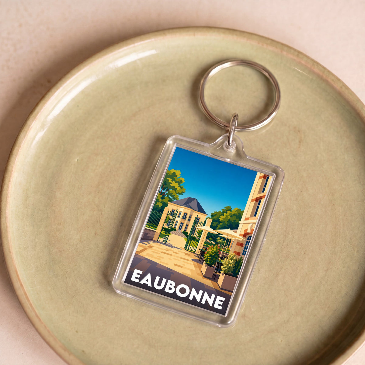Porte-clés souvenir de la ville d'Eaubonne avec une illustration stylisée.
