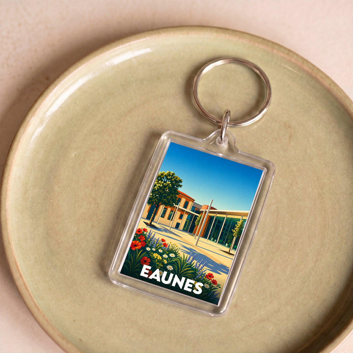 Porte-clés souvenir de la ville d'Eaunes avec une illustration colorée et stylisée.