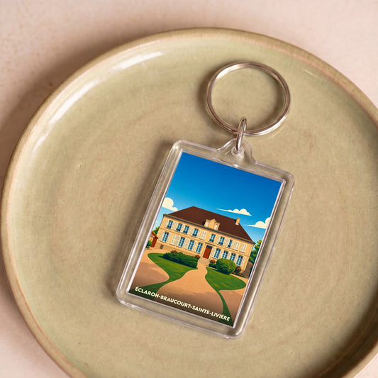 Porte-clés souvenir de la commune d'Éclaron-Braucourt-Sainte-Livière avec une illustration stylisée d'un manoir.