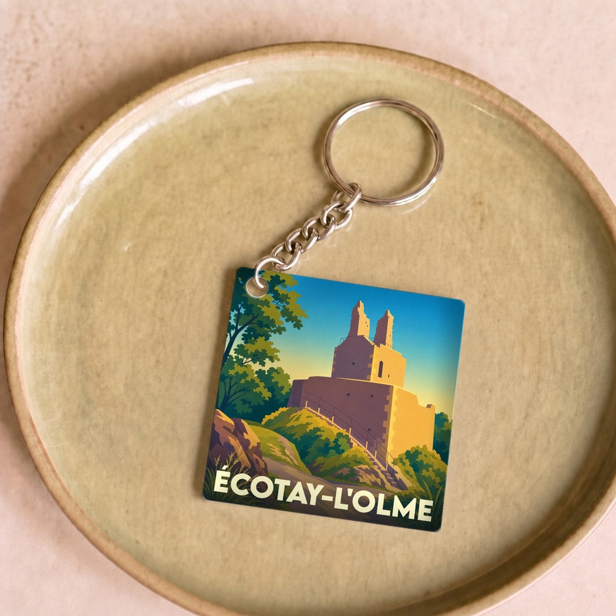 Porte-clés souvenir de la ville de Écotay-l'Olme avec une illustration stylisée d'un monument historique.