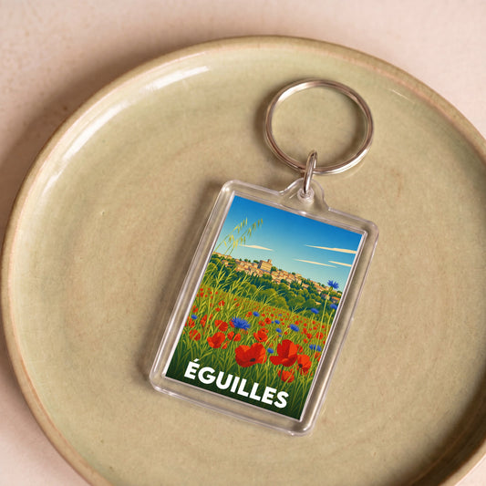 Porte-clés souvenir de la ville d'Éguilles avec une illustration stylisée de paysages provençaux.