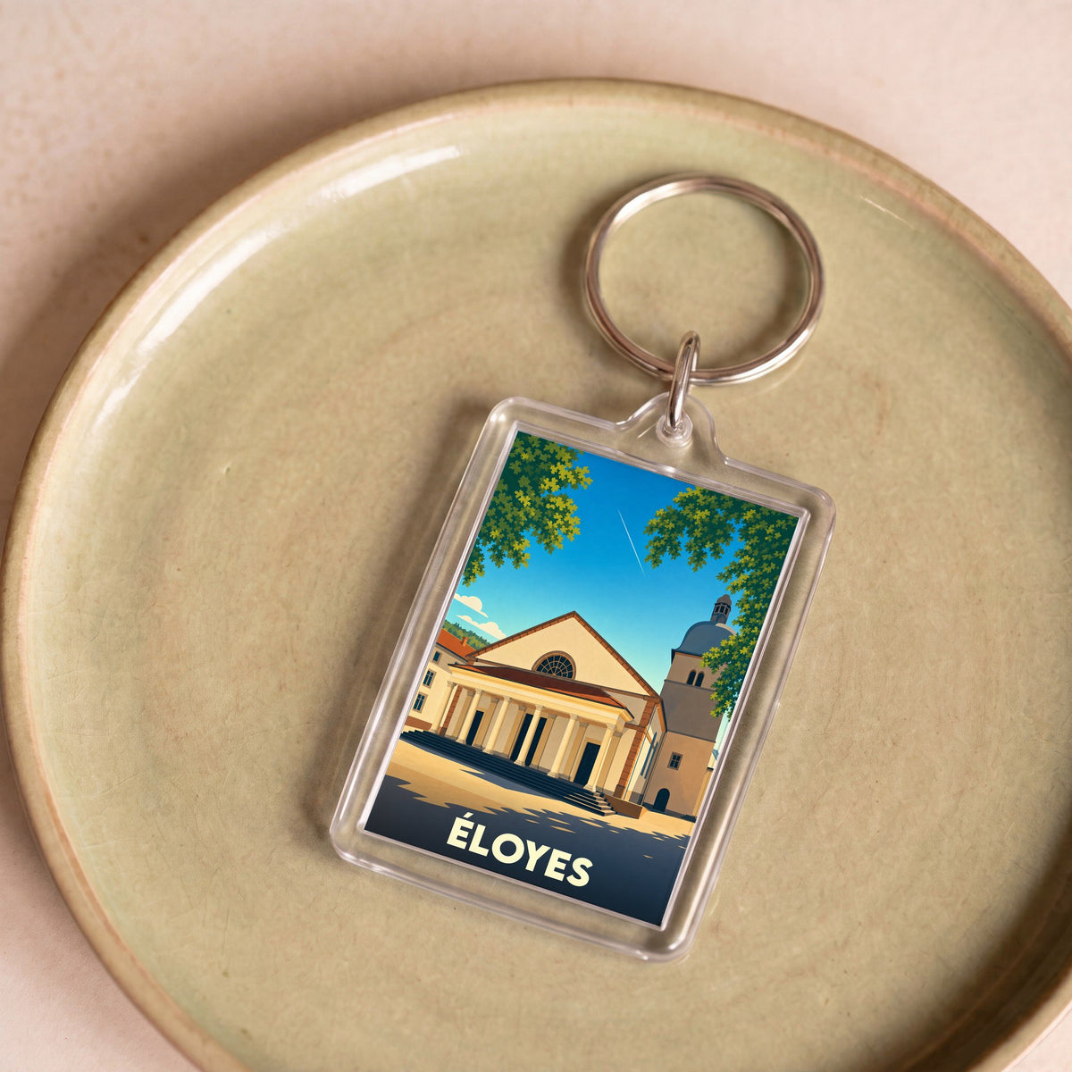 Porte-clés souvenir de la ville d'Éloyes avec une illustration stylisée.