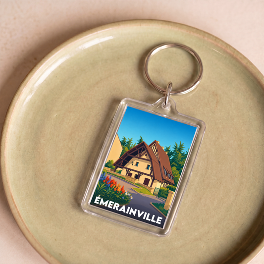 Porte-clés souvenir de la ville d'Émerainville avec une illustration stylisée d'une maison traditionnelle.