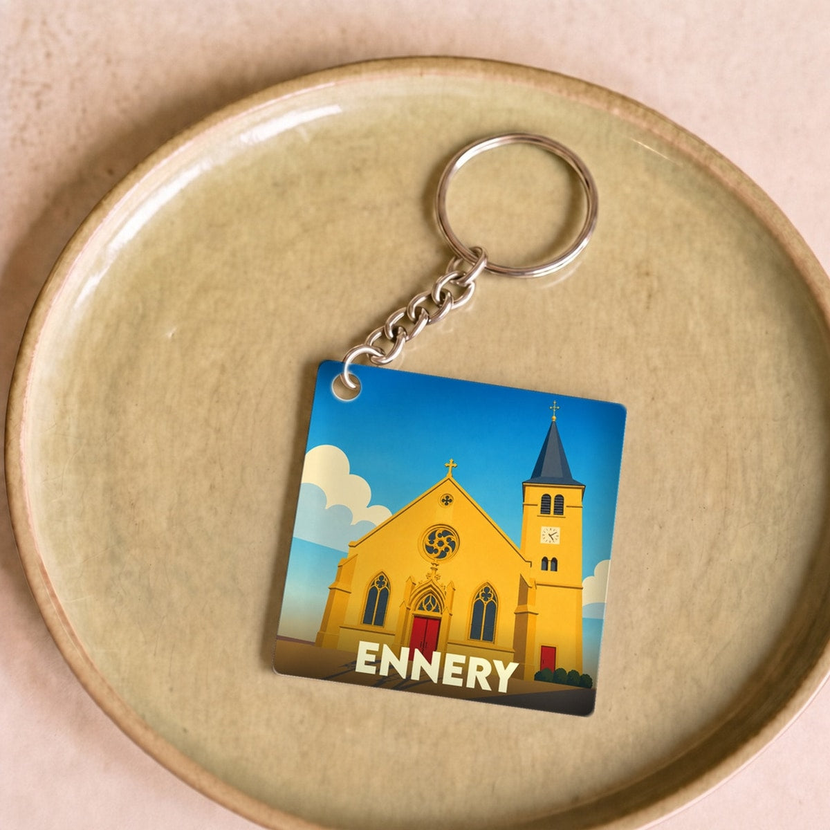 Porte-clés souvenir de la ville d'Ennery avec une illustration stylisée.