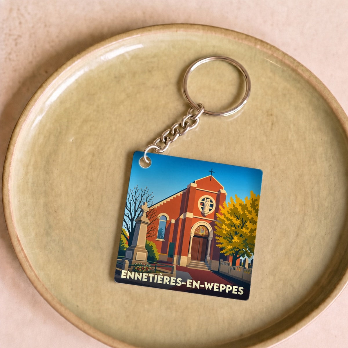 Porte-clés souvenir de la ville d'Ennetières-en-Weppes avec une illustration stylisée de son église.