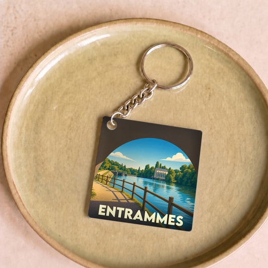 Porte-clés souvenir de la ville d'Entrammes avec une illustration stylisée d'un paysage de bord de rivière.