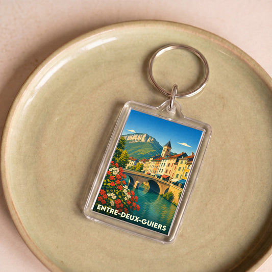 Porte-clés souvenir de la ville d'Entre-deux-Guiers avec une illustration stylisée d'un pont et de montagnes.