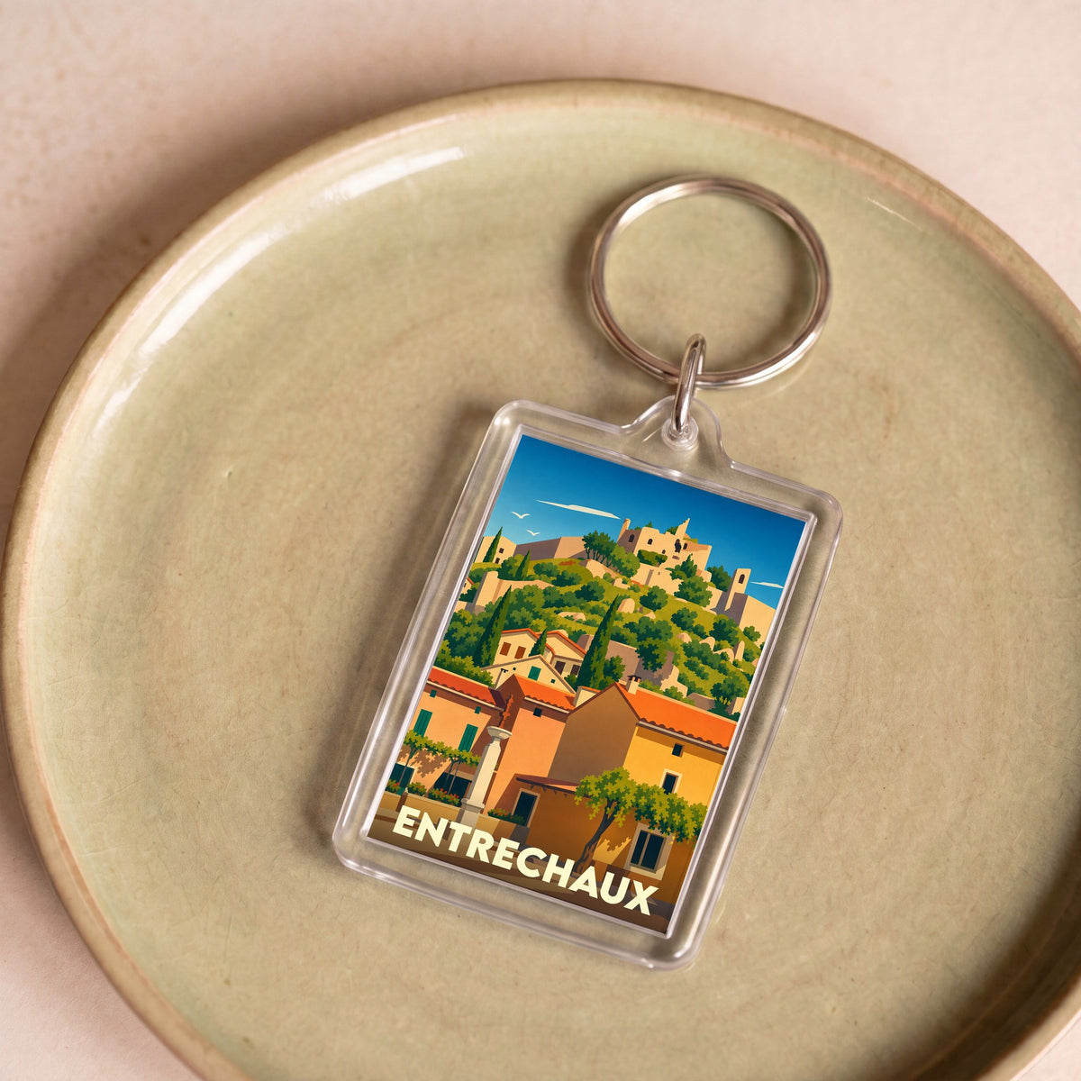 Porte-clés souvenir de la ville d'Entrechaux avec une illustration stylisée.