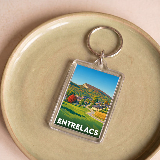 Porte-clés souvenir de la ville d'Entrelacs avec une illustration stylisée de paysages montagneux.