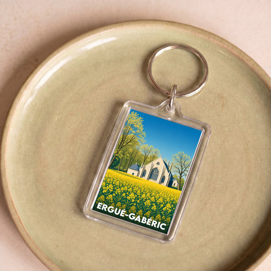 Porte-clés souvenir de la ville d'Ergué-Gabéric avec une illustration stylisée d'une église dans un champ.