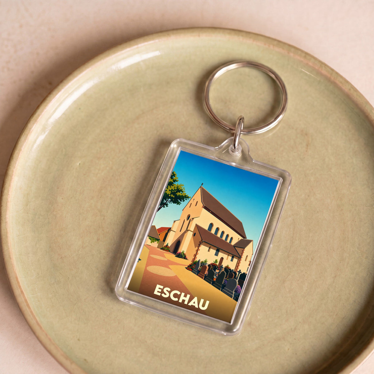 Porte-clés souvenir de la ville d'Eschau avec une illustration stylisée de son église abbatiale.