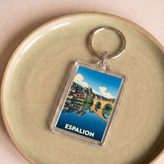 Porte-clés souvenir de la ville d'Espalion avec une illustration stylisée de son pont célèbre se reflétant dans l'eau.