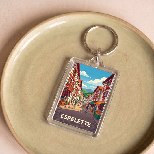 Porte-clés souvenir de la ville d'Espelette avec une illustration stylisée de ses rues typiques.