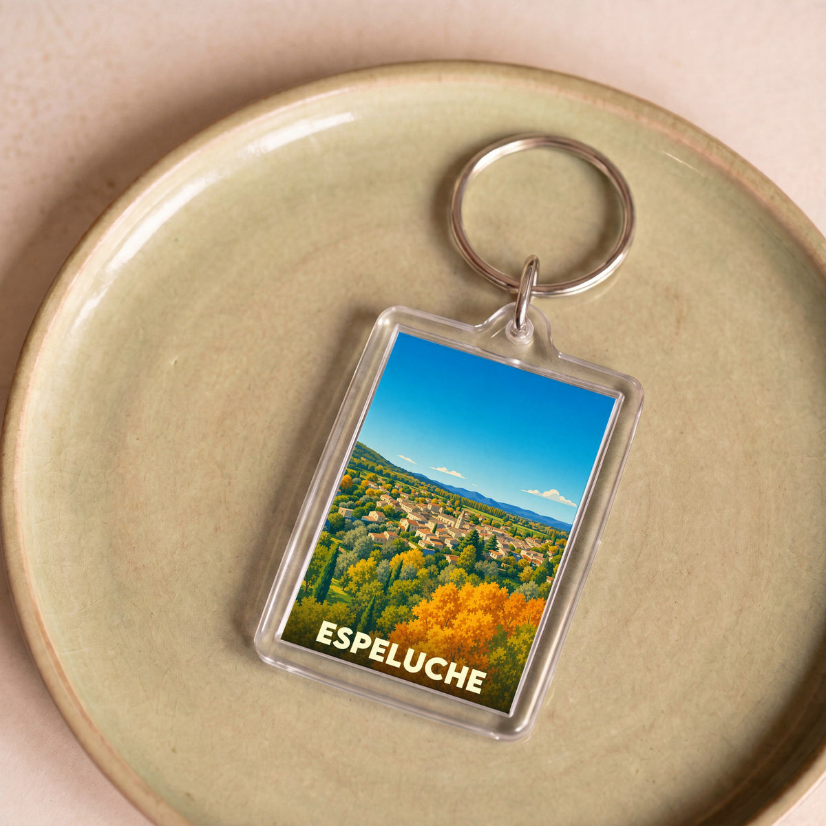 Porte-clés souvenir de la ville d'Espeluche avec une illustration stylisée de son paysage vallonné.