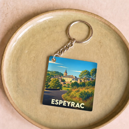Porte-clés souvenir de la ville d'Espeyrac avec une illustration stylisée d'un paysage de village.