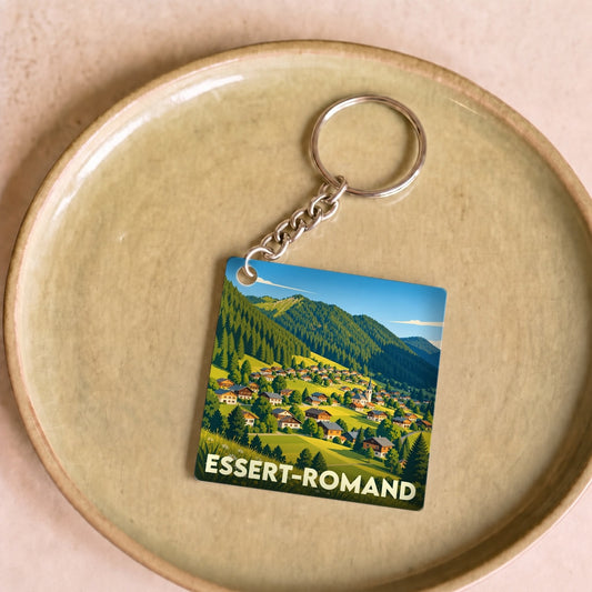 Porte-clés souvenir de la ville d'Essert-Romand illustré d'un paysage de montagne et de chalets.
