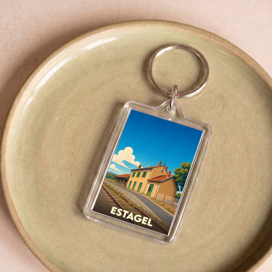Porte-clés souvenir de la ville de Estagel avec une illustration stylisée de sa gare ferroviaire.