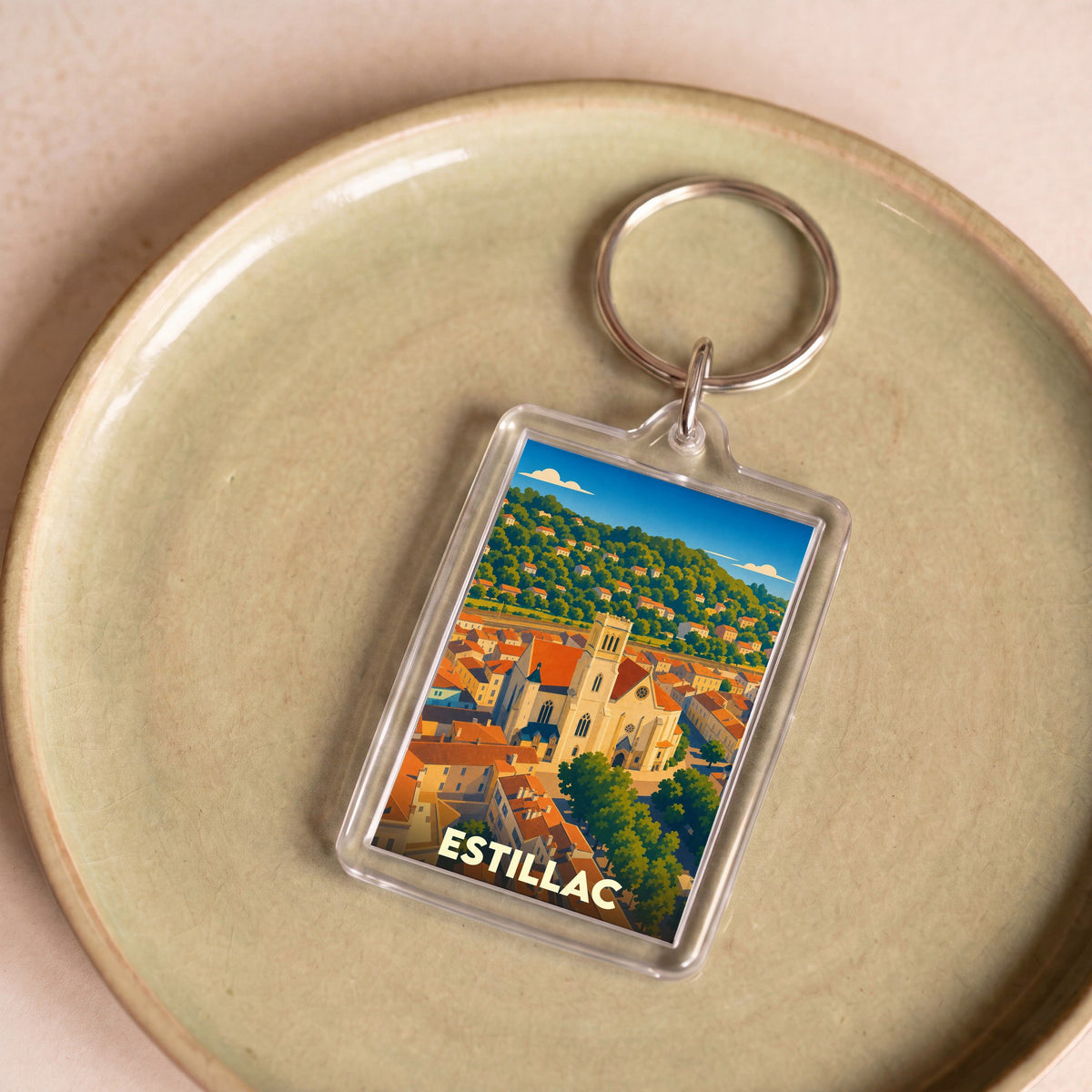 Porte-clés souvenir de la ville d'Estillac avec une illustration stylisée de son église et de ses collines.