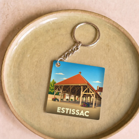 Porte-clés souvenir de la ville d'Estissac avec une illustration stylisée de sa halle historique.