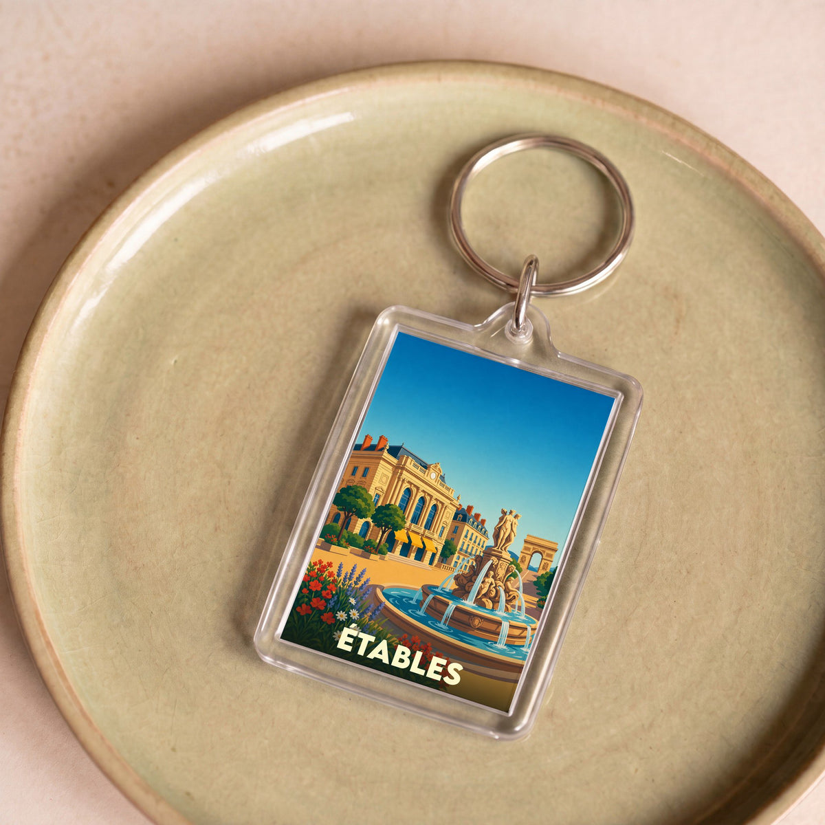 Porte-clés souvenir de la ville de Étables avec une illustration stylisée d'une place ensoleillée.
