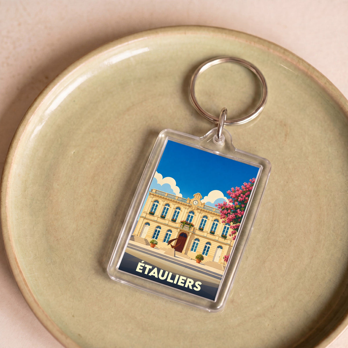 Porte-clés souvenir de la ville d'Étauliers avec une illustration stylisée de sa mairie.