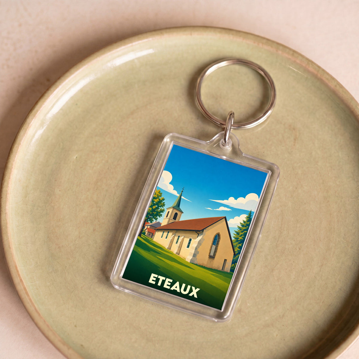 Porte-clés souvenir de la ville d'Eteaux avec une illustration stylisée de son église.